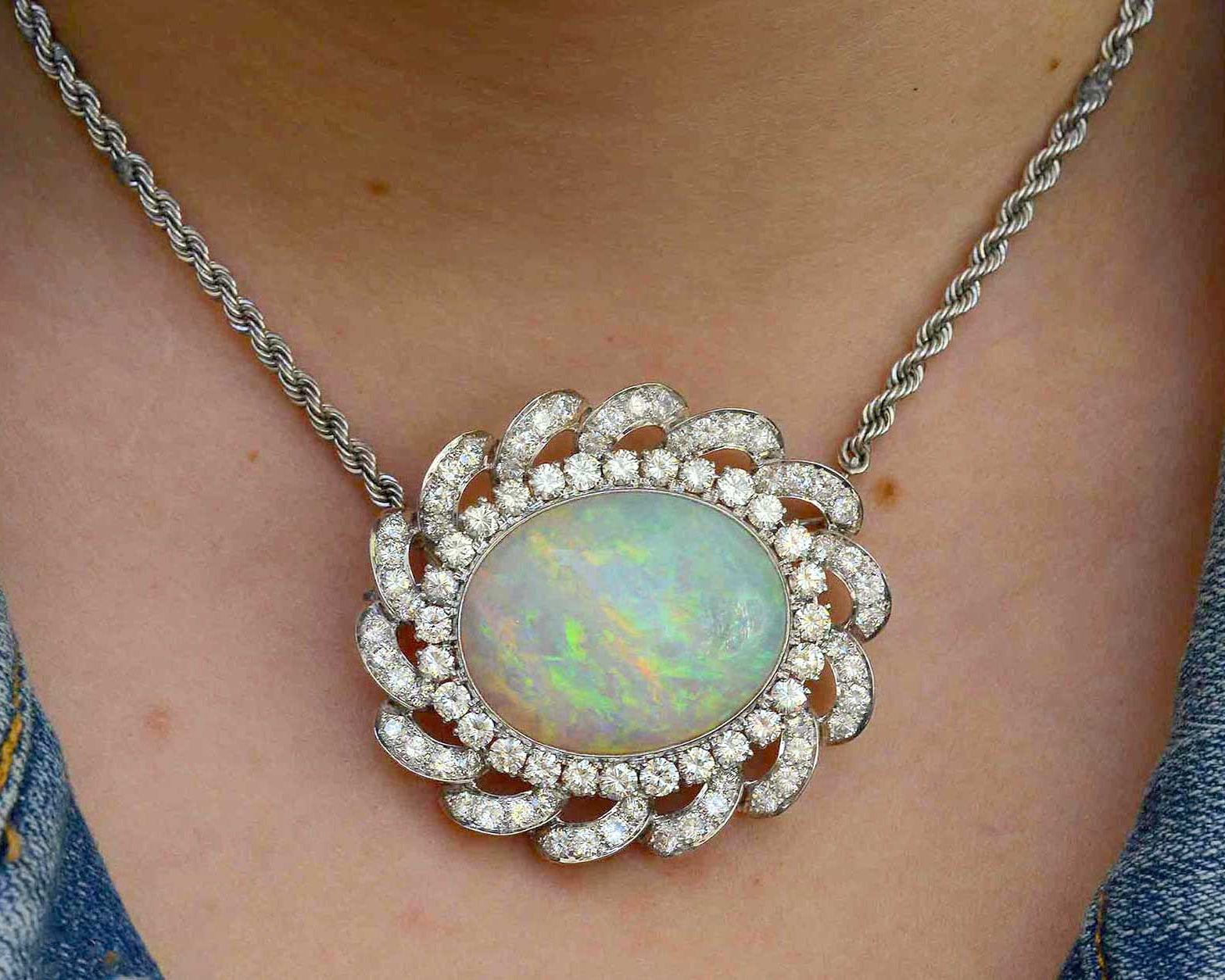 This cabochon oval opal is set in a diamond halo statement necklace.