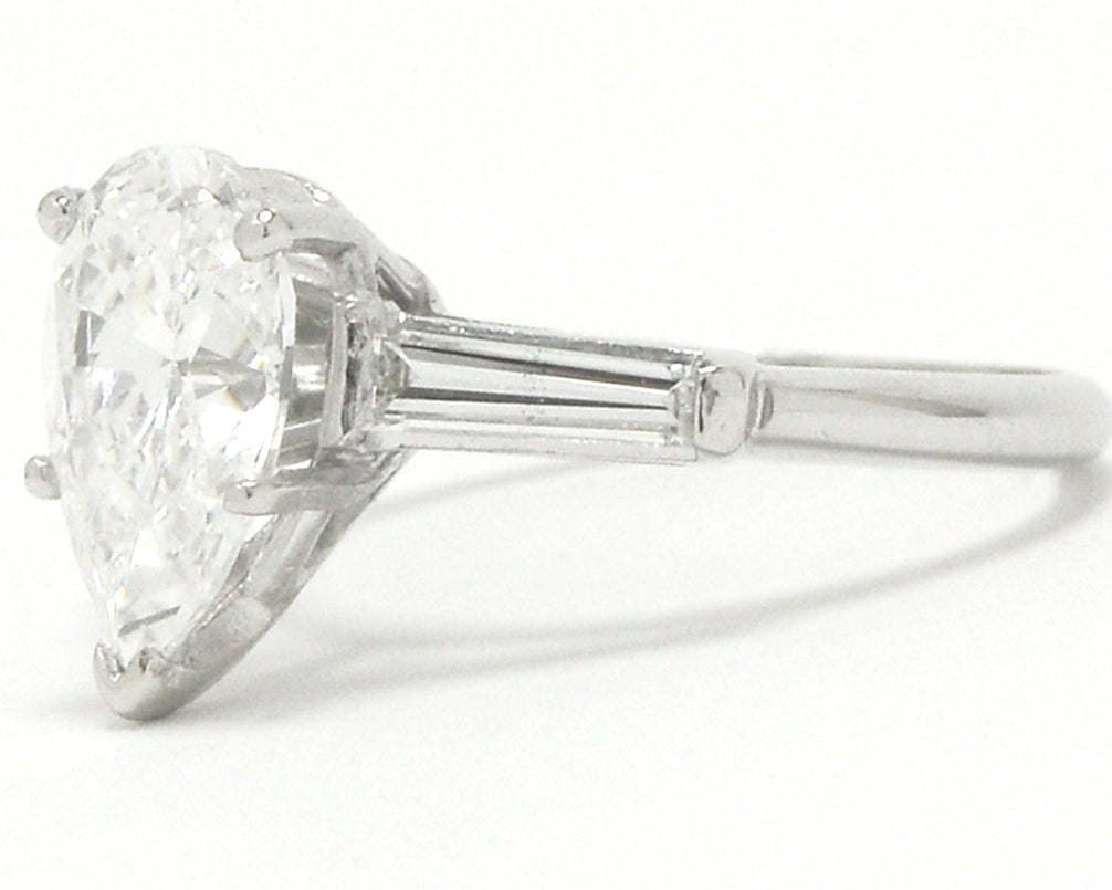 A platinum pear cut diamond solitaire wedding ring with baguette cut accent gems.