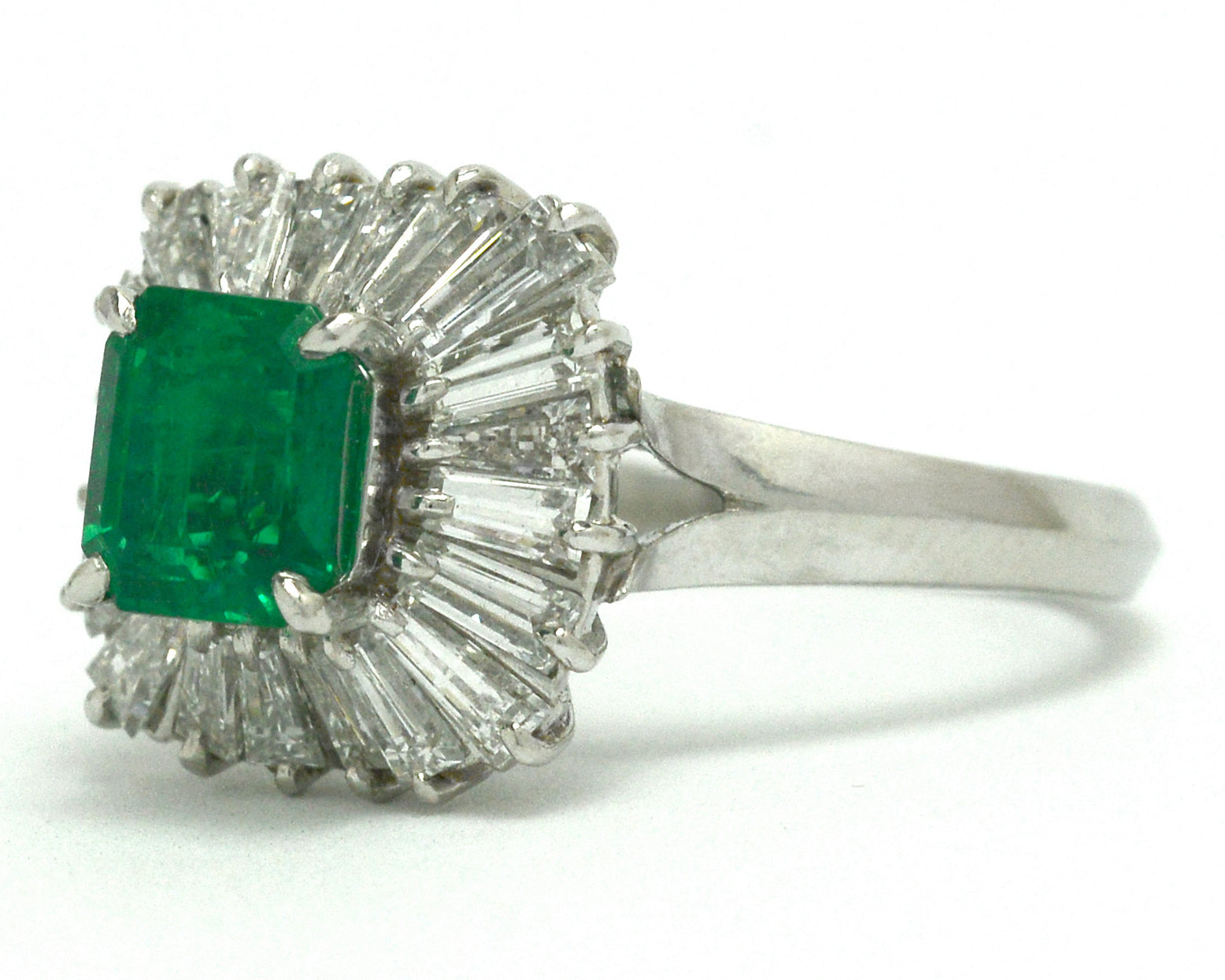 A platinum emerald ballerina ring, called that for its radiated design of diamonds halo.