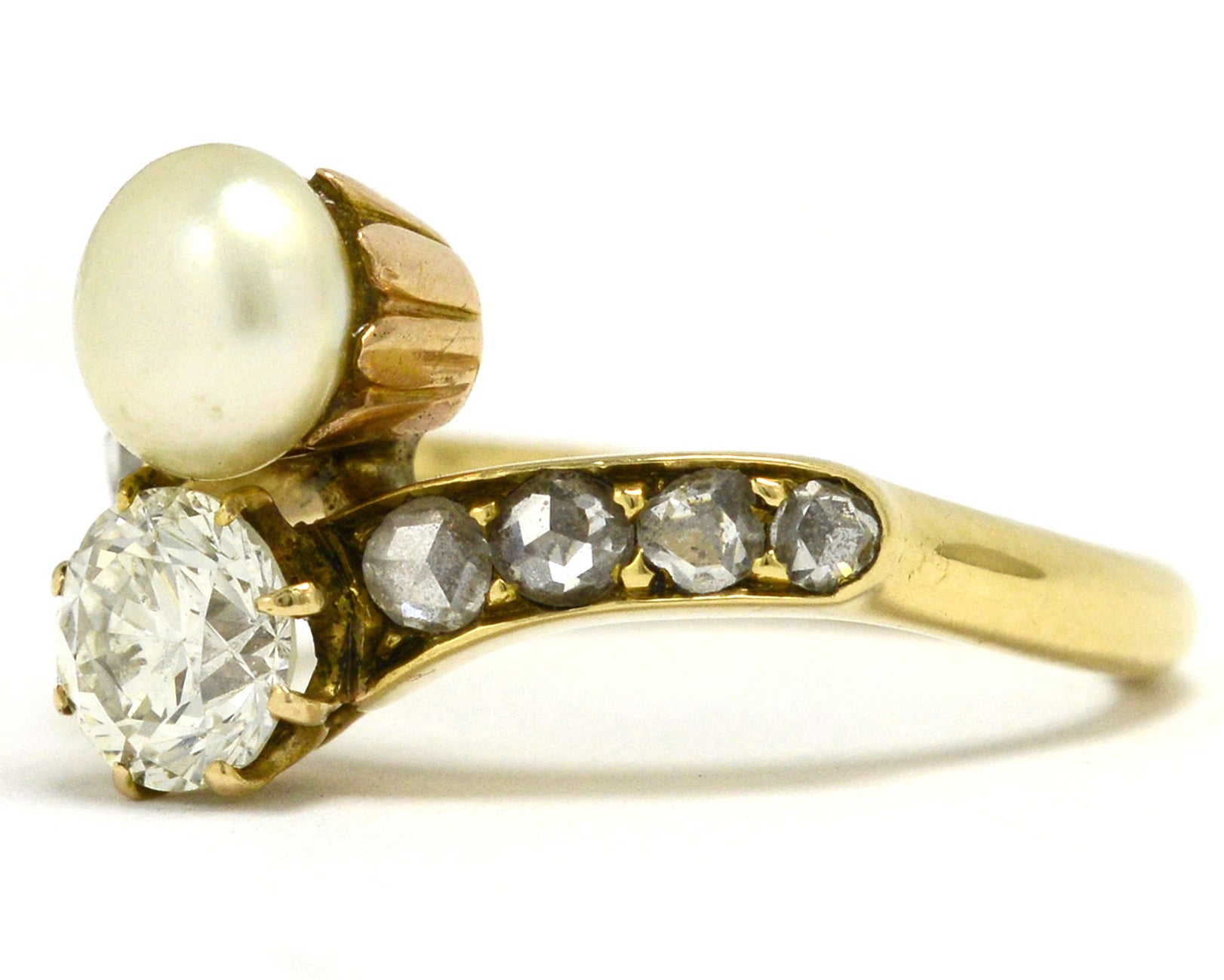 An Art Nouveau diamond and pearl two stone engagement ring.