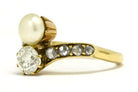 An Art Nouveau diamond and pearl two stone engagement ring.