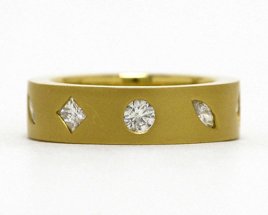 Round, princess and marquise diamonds set in a modern, 18k gold band.