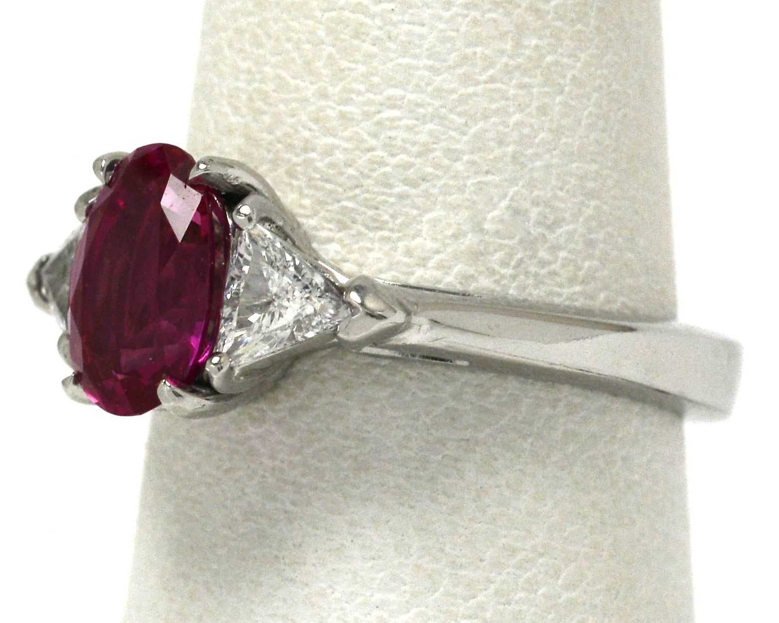 A 3 stone natural pink sapphire and 2 triangle diamonds engagement ring.