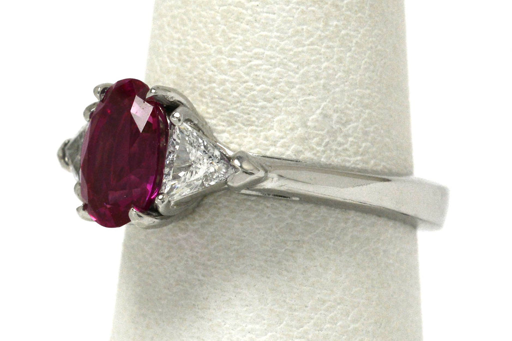 A 3 stone natural pink sapphire and 2 triangle diamonds engagement ring.
