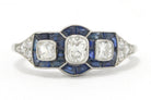 A 3 old mine cushion cut diamond engagement ring accented surrounded by blue sapphires.