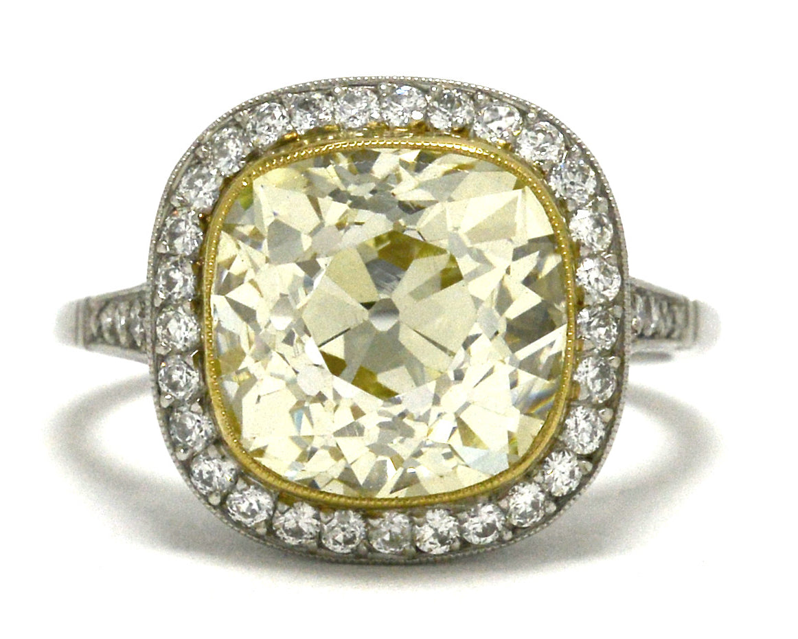 A five carat, fancy light yellow cushion diamond engagement ring.