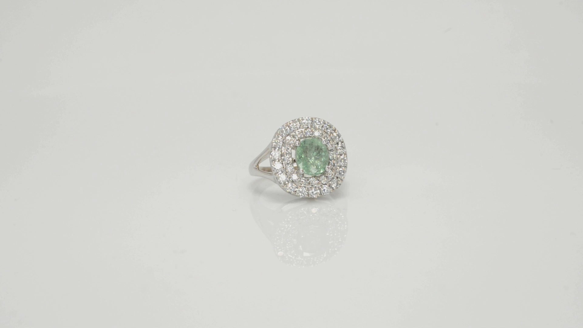 A sparkling cushion cut, natural paraiba tourmaline ring surrounded by 2 halos of diamonds.