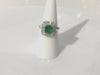 An over 1 carat emerald diamond baguettes platinum halo statement ring.