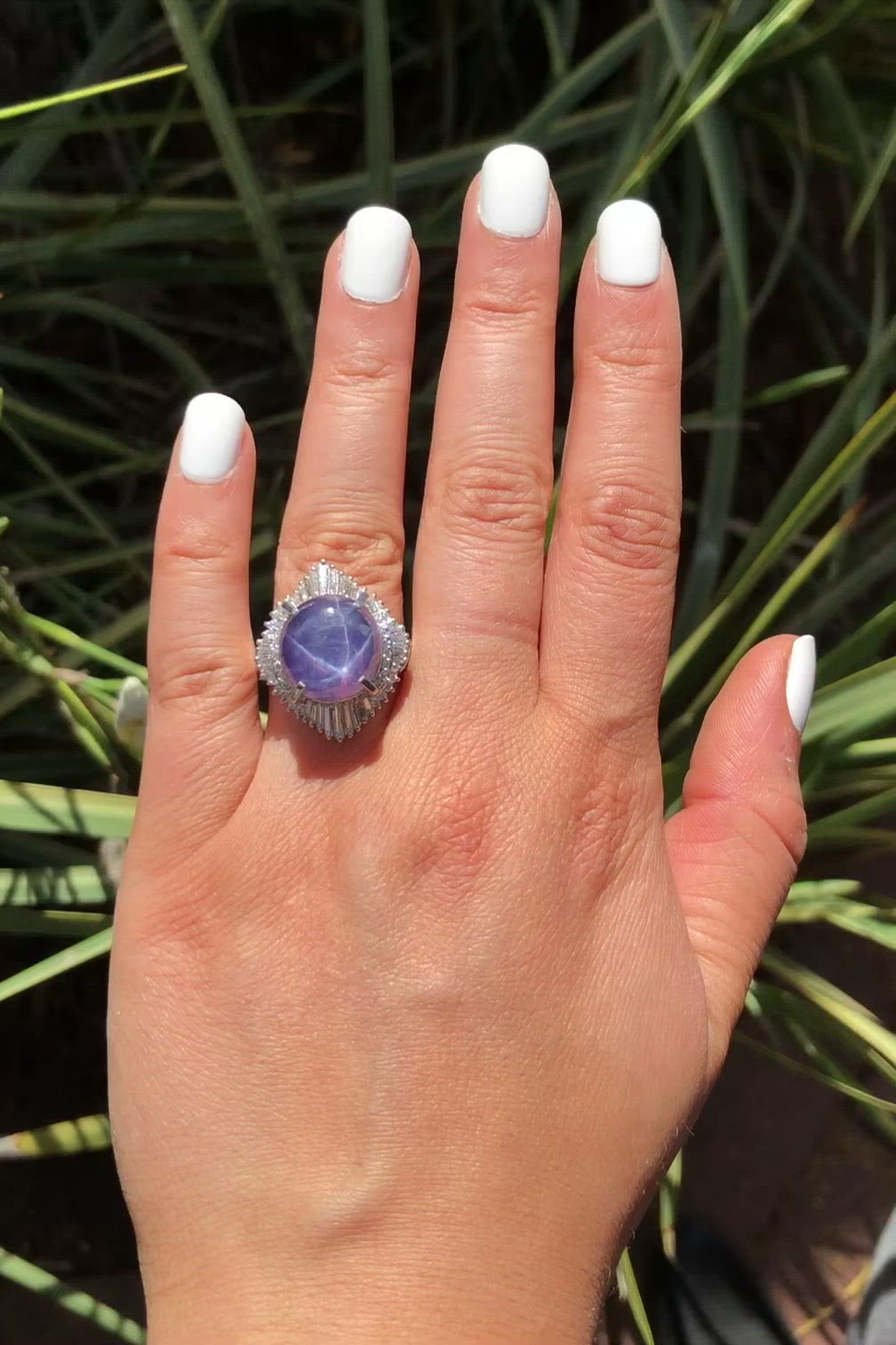 A medium purple star sapphire dome target ring accented by diamonds.