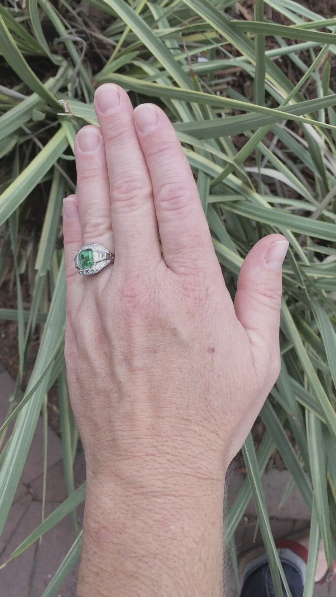 An Art Deco emeralds and diamonds ring crafted of palladium.