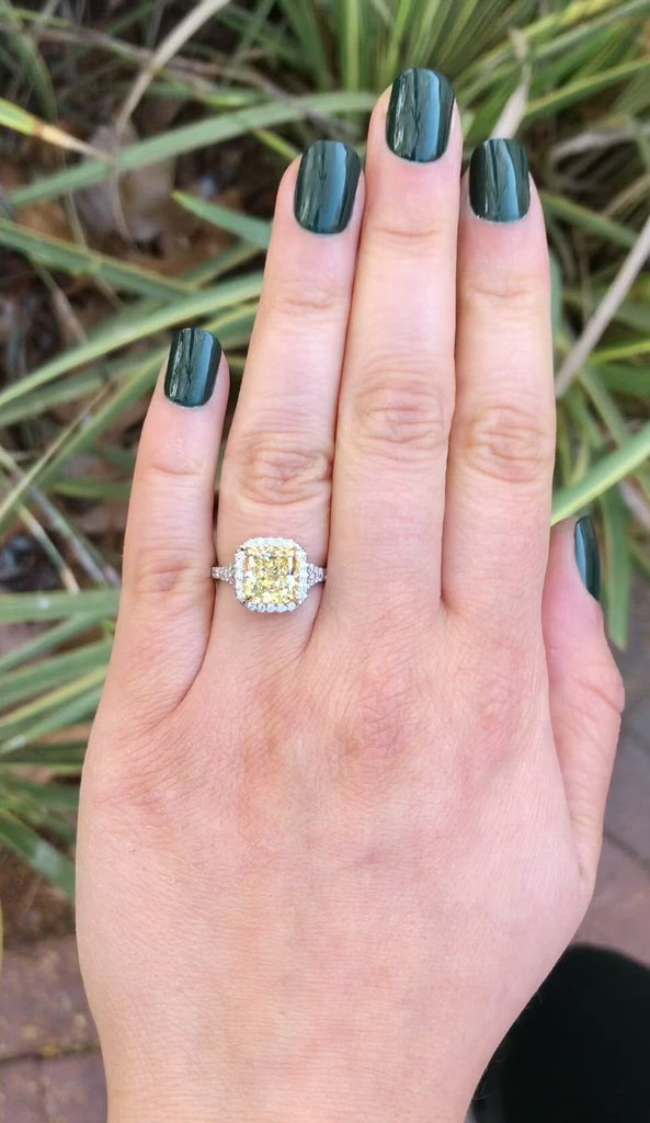 A platinum and 18k gold modern estate diamond halo engagement ring.