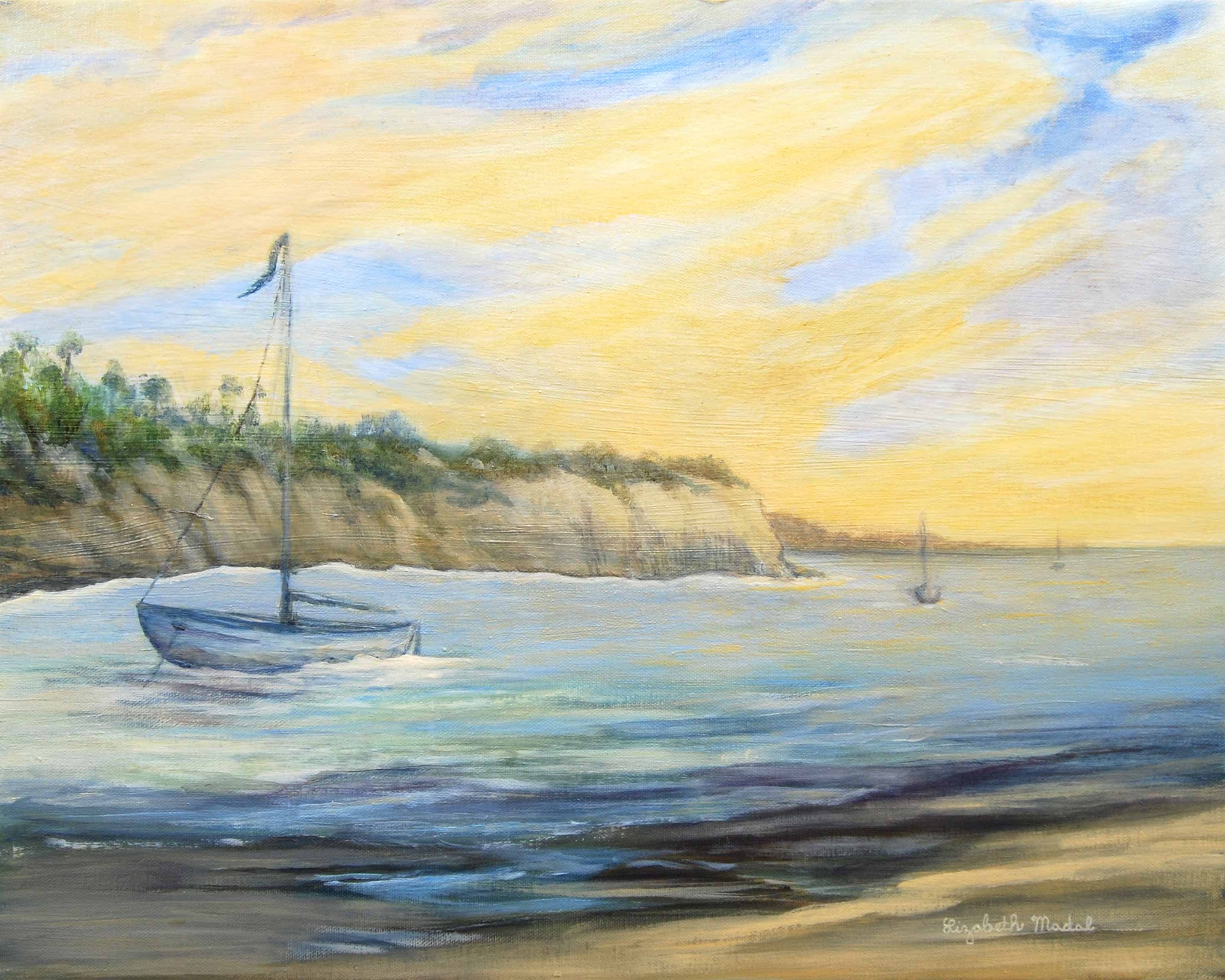 An anchored boat on shore with a blue and yellow sky.
