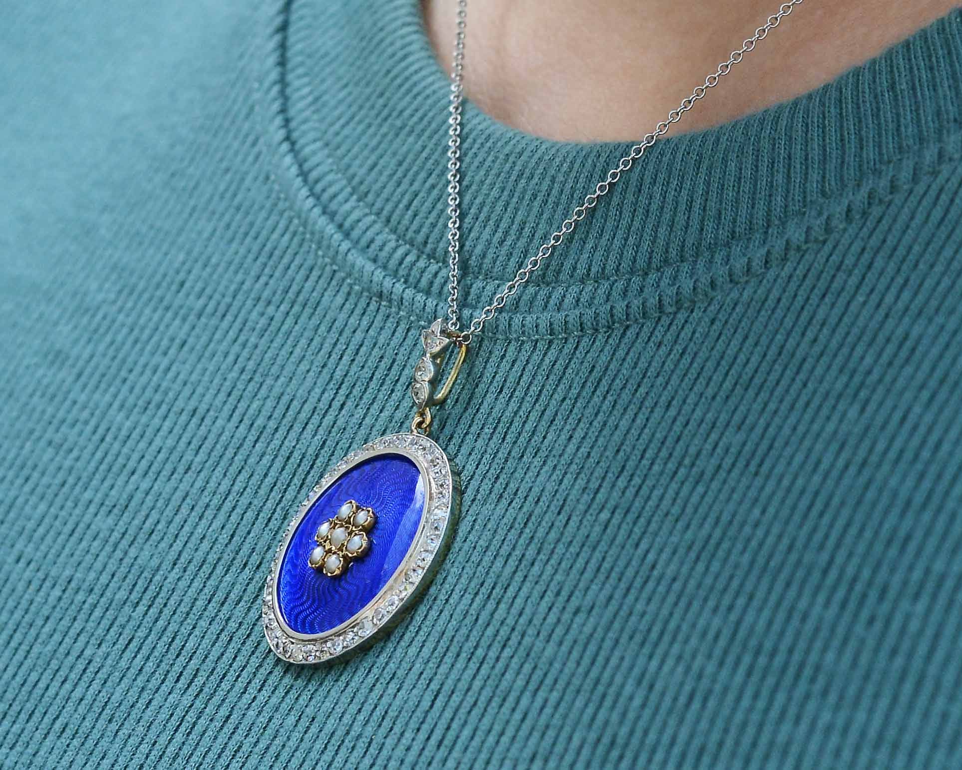 Rich, shimmering royal blue enamel lines this diamond halo pendant necklace.