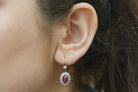 Oval rubies target leverback earrings surrounded by round diamonds.
