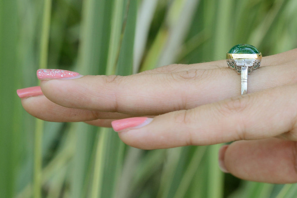 A cabochon cut Colombian emerald, platinum engagement ring with a gold bezel.
