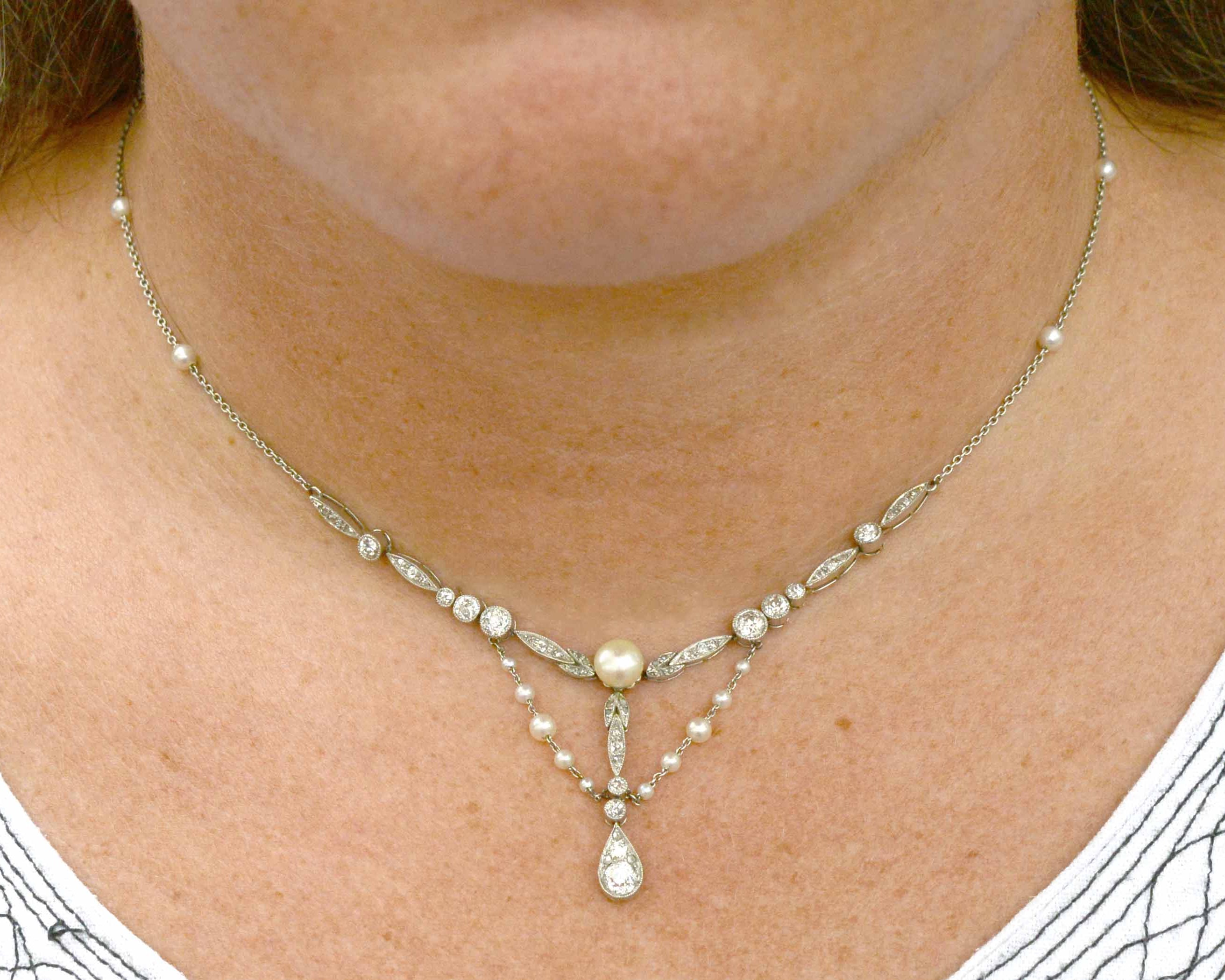 An Edwardian bib style platinum lavalier necklace with pearl drapes.