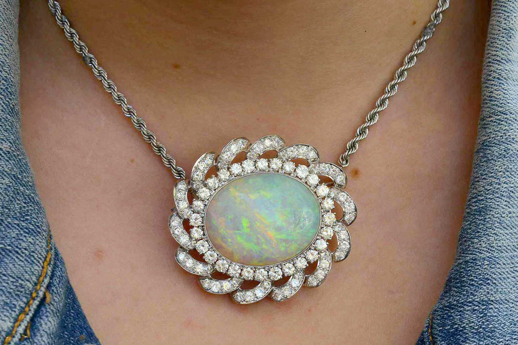 This cabochon oval opal is set in a diamond halo statement necklace.