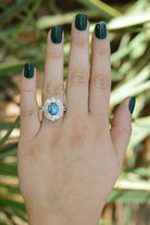 An 18k white gold blue zircon ring with double diamond halo.