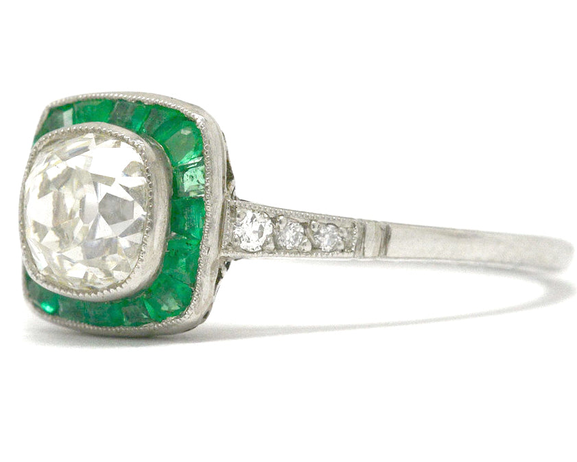A rounded square diamond and emerald halo engagement ring.