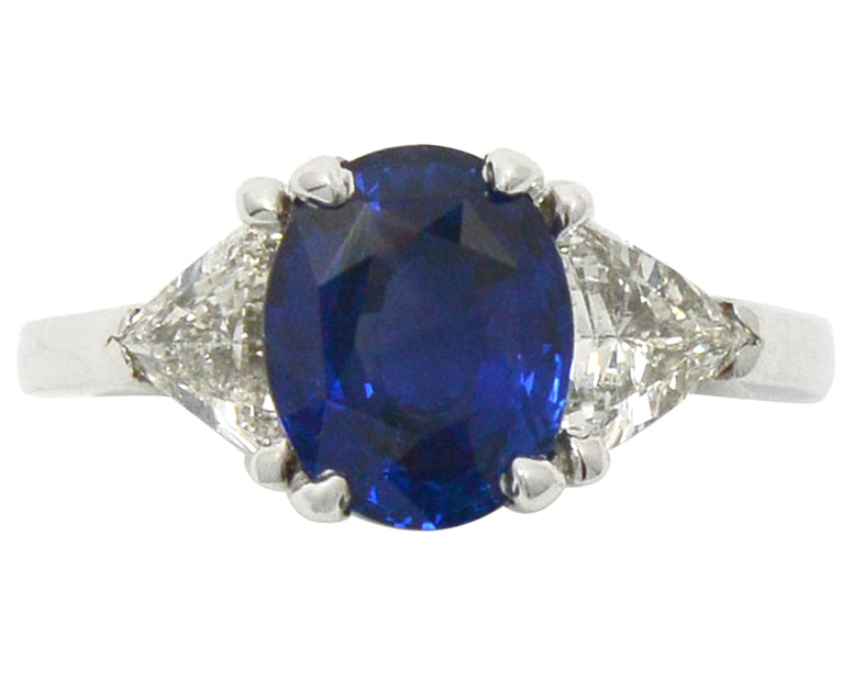 An oval 3 carat blue ceylon sapphire, three stone engagement ring.