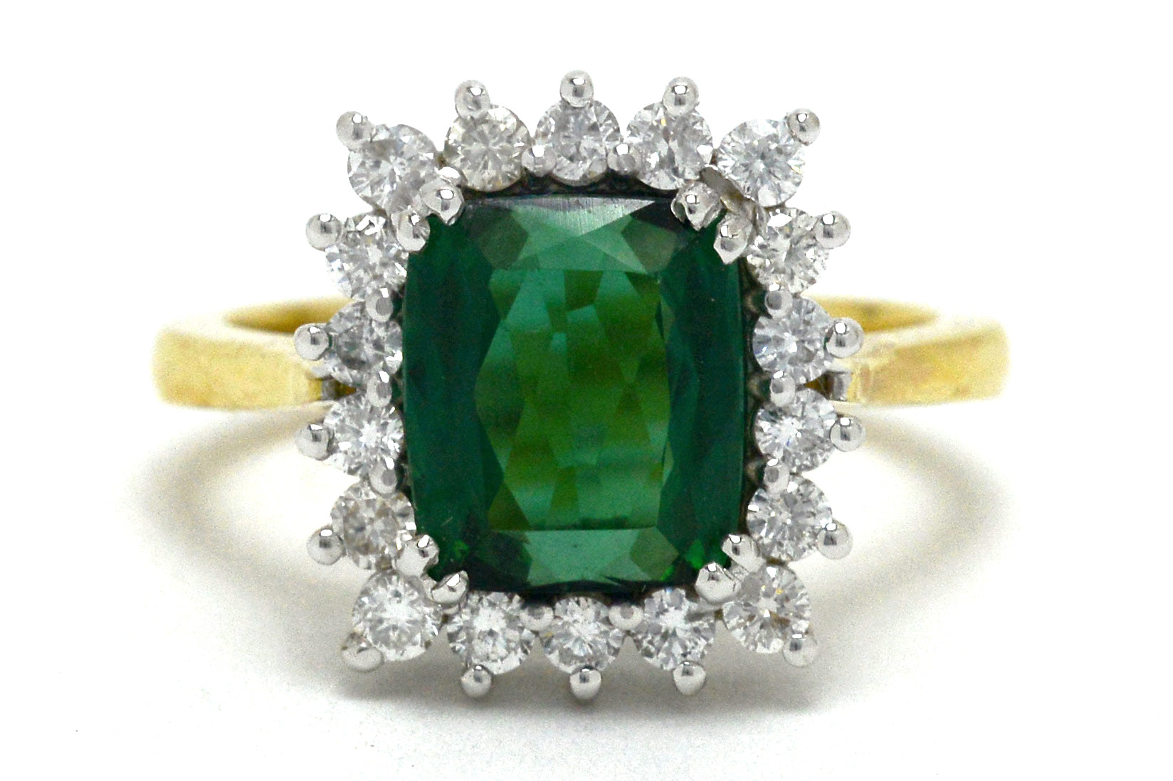 A Princess Diana style green tourmaline diamond target engagement ring.