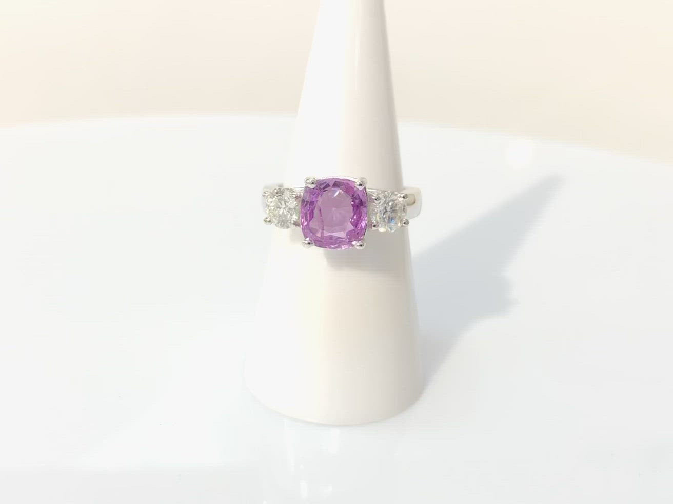 A three stone pink sapphire and two diamonds, white gold engagement ring.