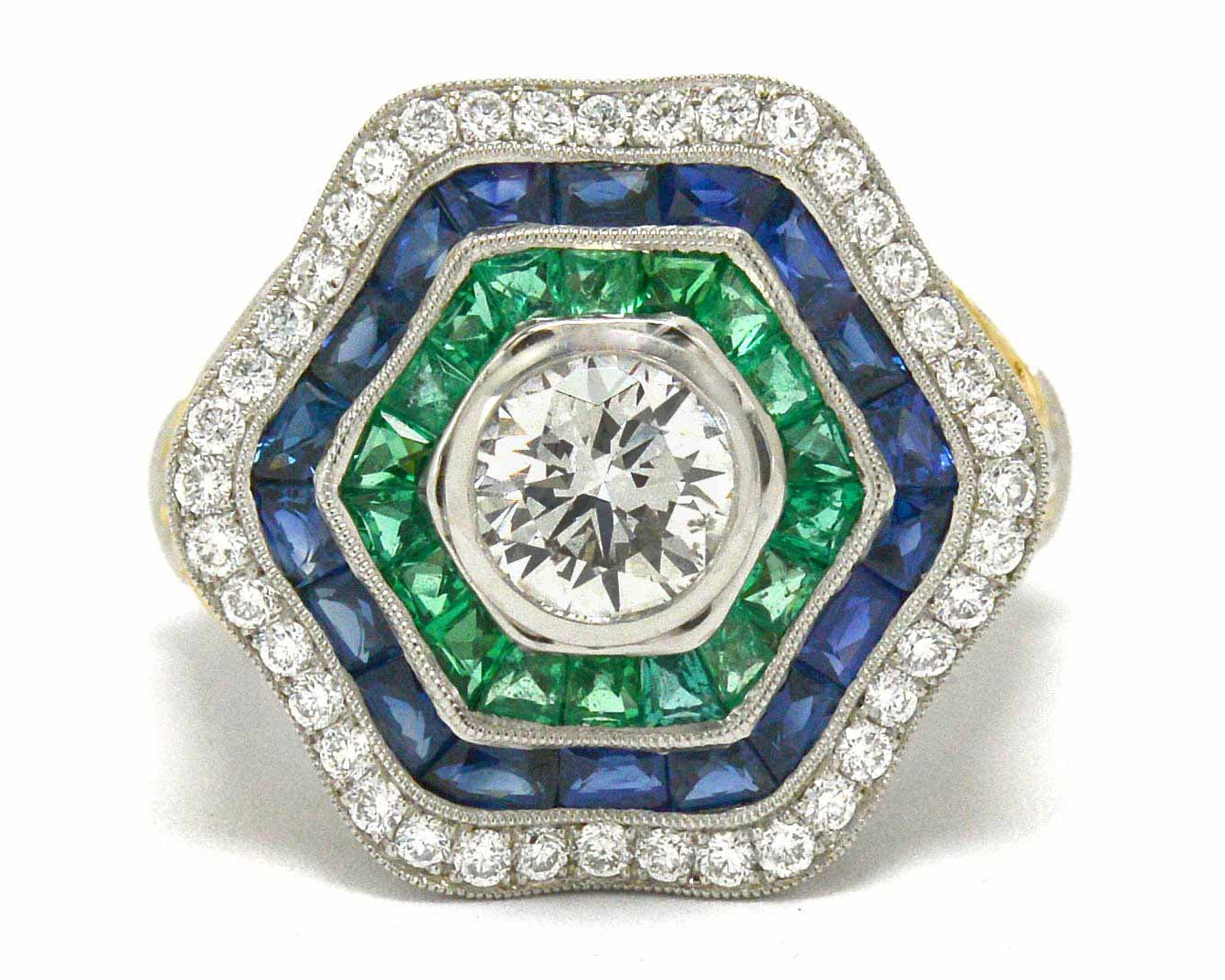 A platinum hexagon ballerina ring with diamonds, emeralds and sapphires.