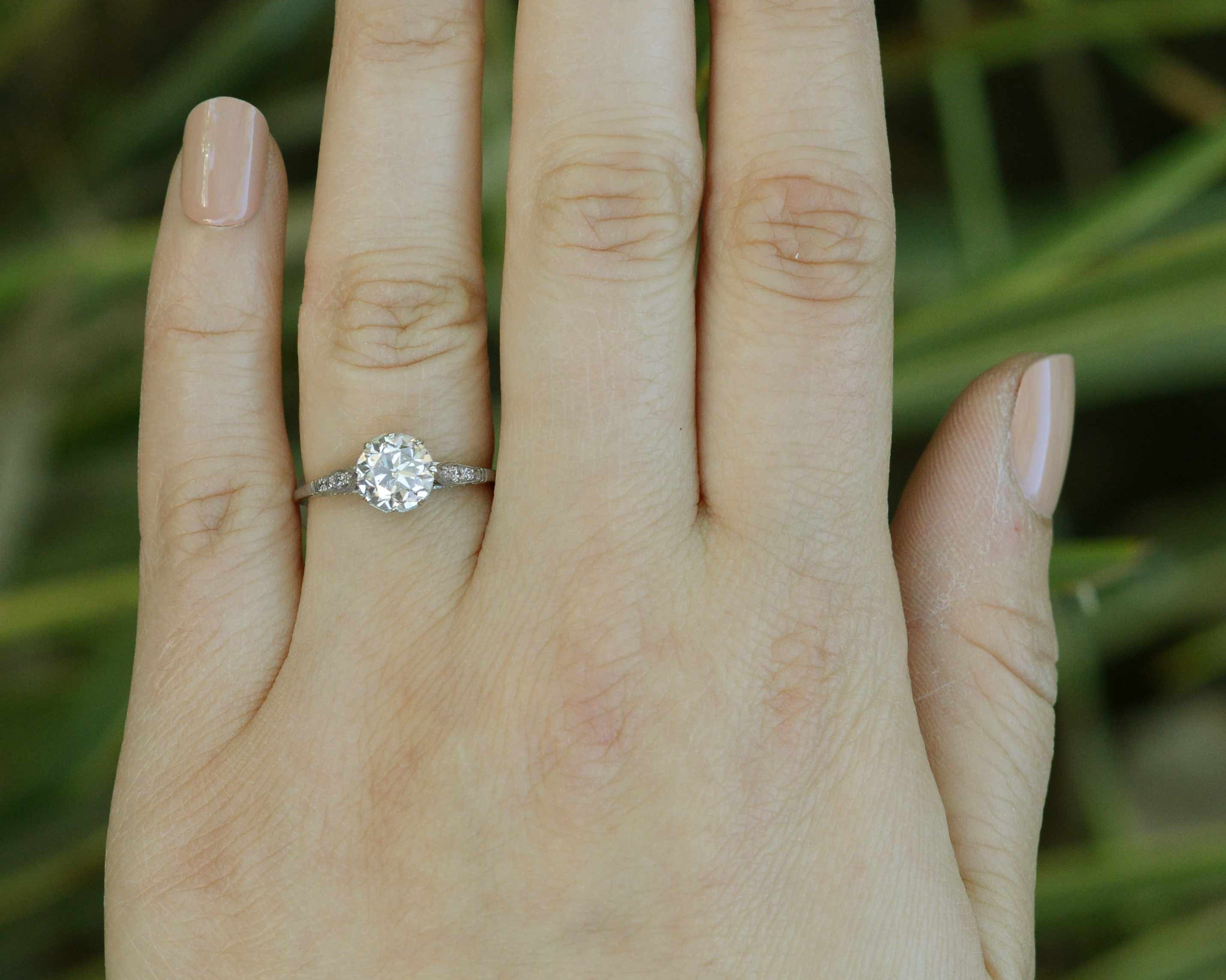 A large one carat diamond engagement ring with accent diamonds on the shoulder and setting.