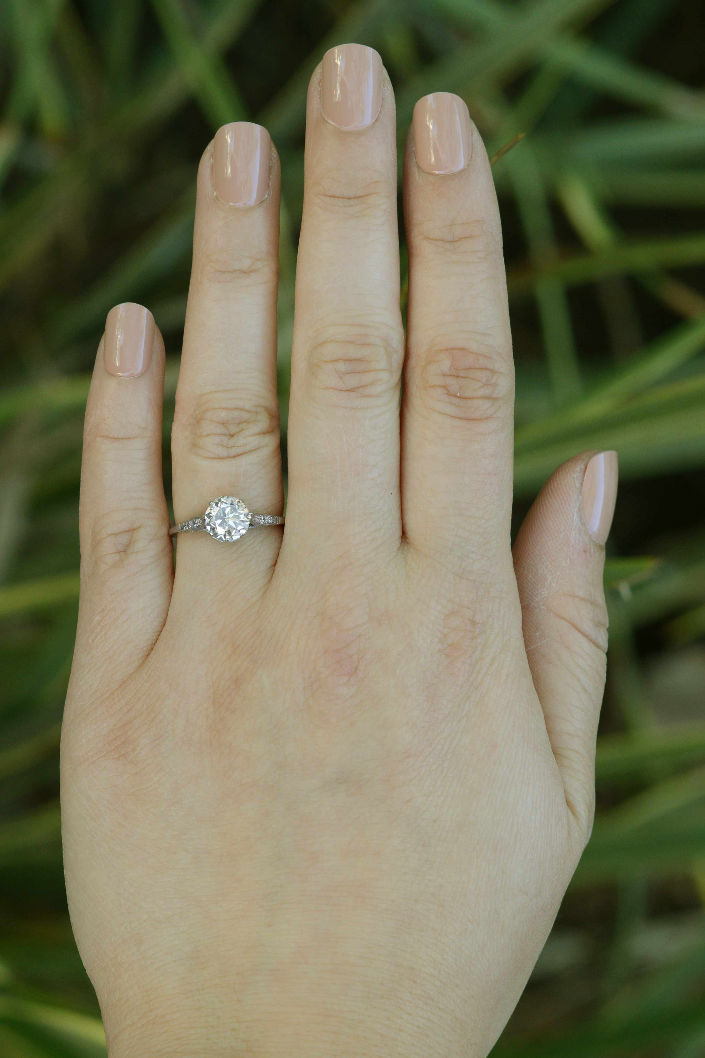A large one carat diamond engagement ring with accent diamonds on the shoulder and setting.