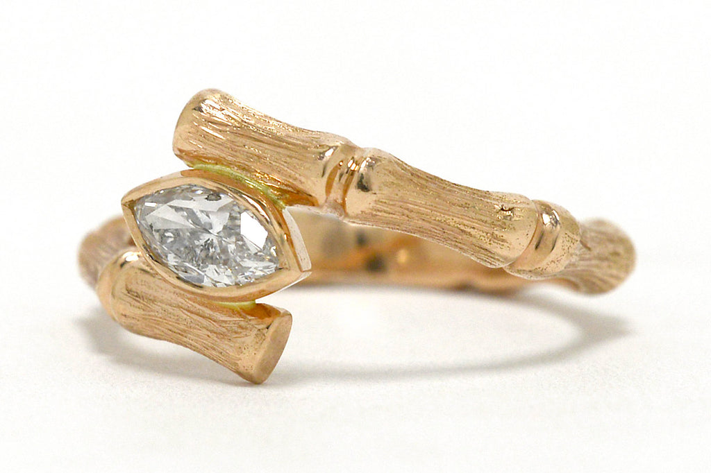 A rose gold diamond bamboo pattern solitaire ring.