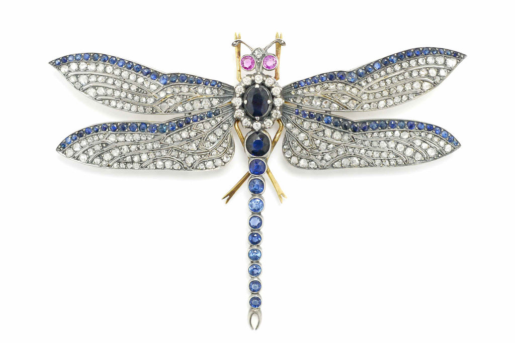 Large oval sapphires and diamonds line this naturalistic dragonfly brooch pin.