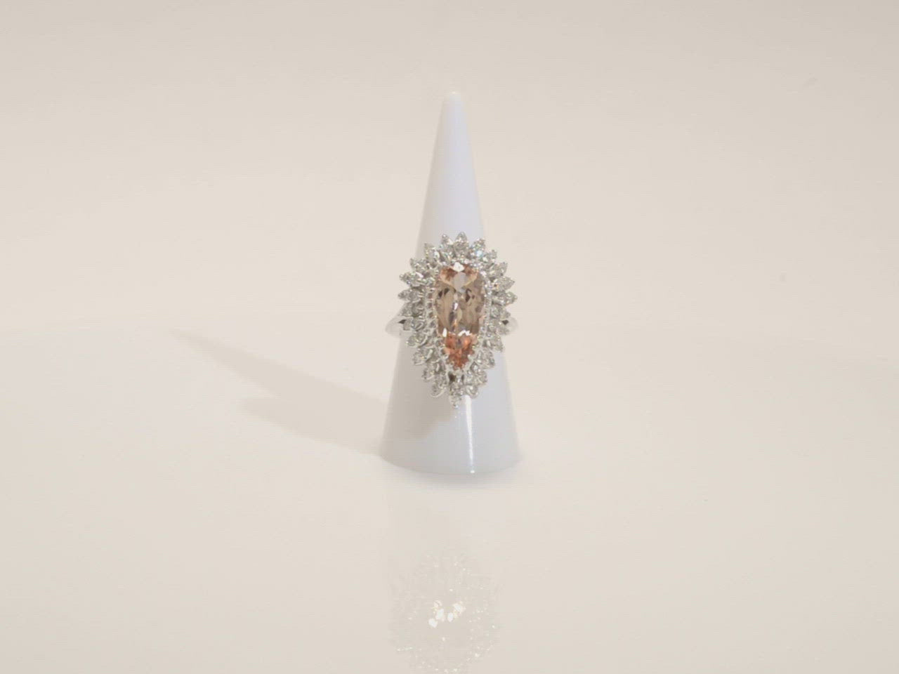 A unique five carat pear cut morganite is set in a large 14k white gold ballerina ring.