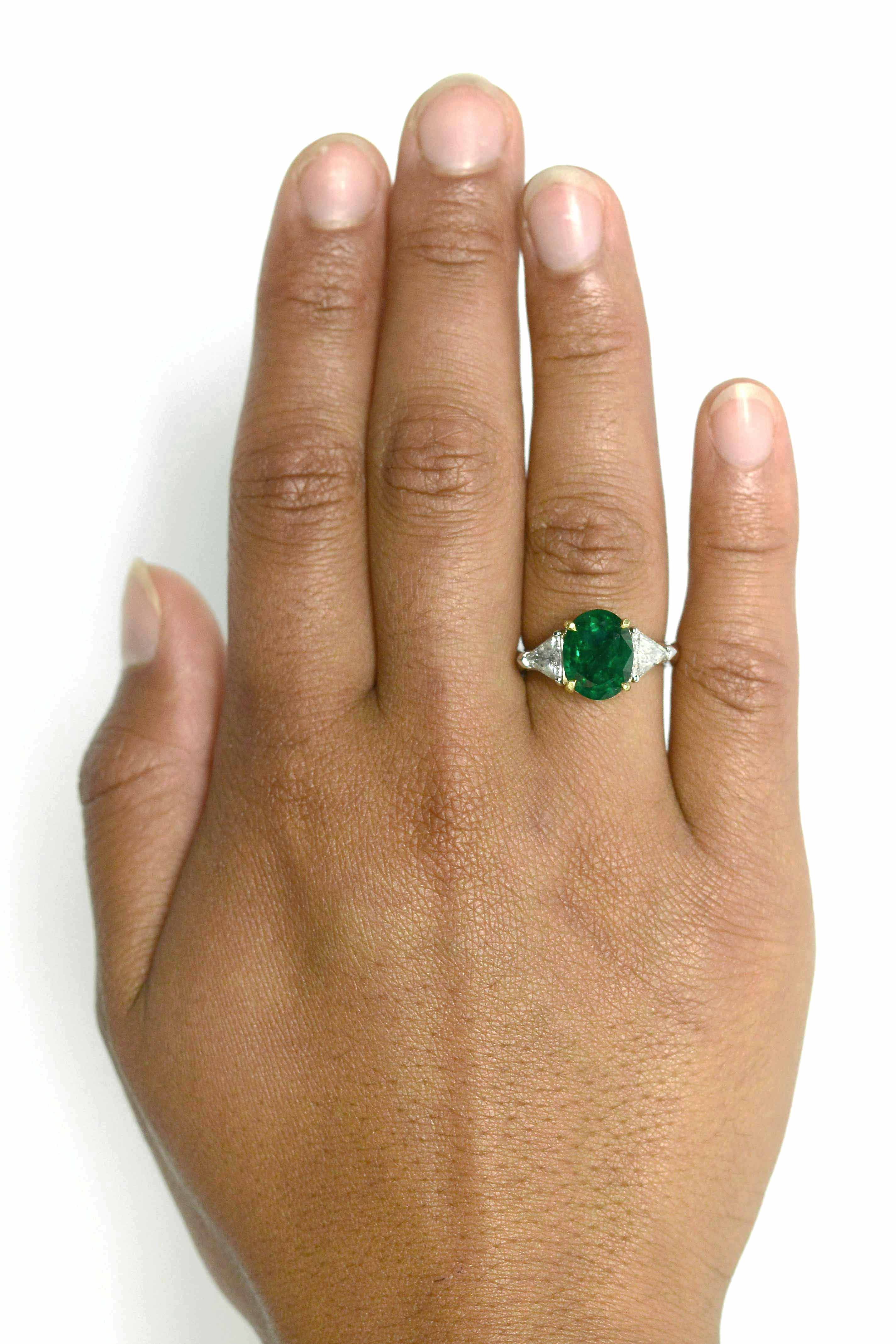 4 prongs secure the emerald of over 3 carats in this modern engagement ring.