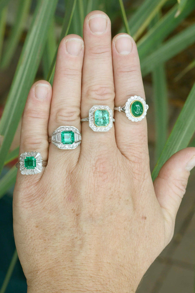 Emerald with diamonds, target and halo wedding rings.