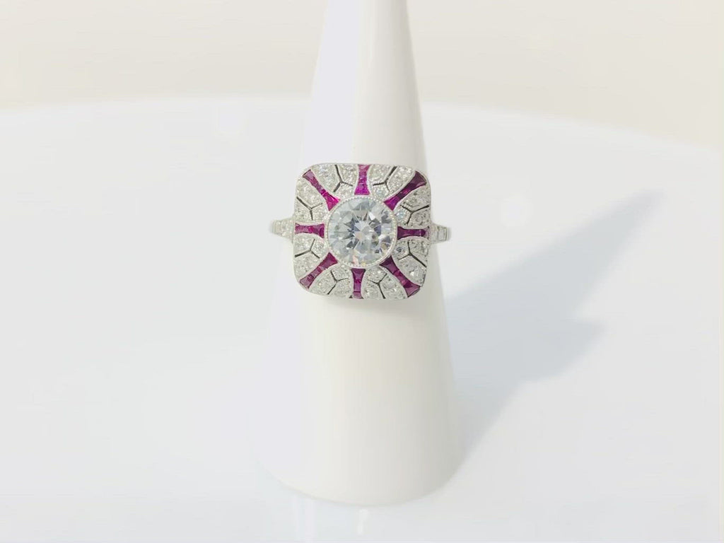 A 1 carat round brilliant diamond engagement ring has a ruby striped design.