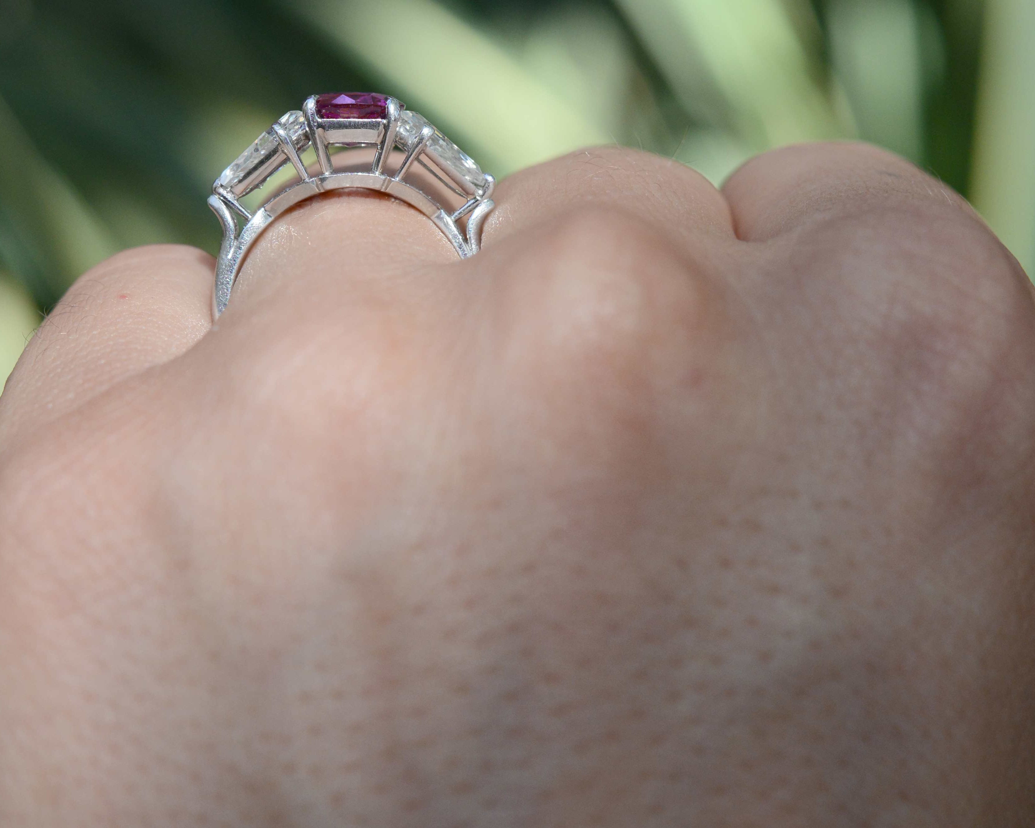 A natural bright pink sapphire set amongst 2 kite cut diamonds in a unique engagment ring.