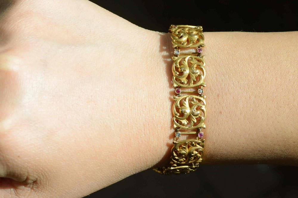 A flower design 18k yellow gold link bracelet with diamonds and rubies.
