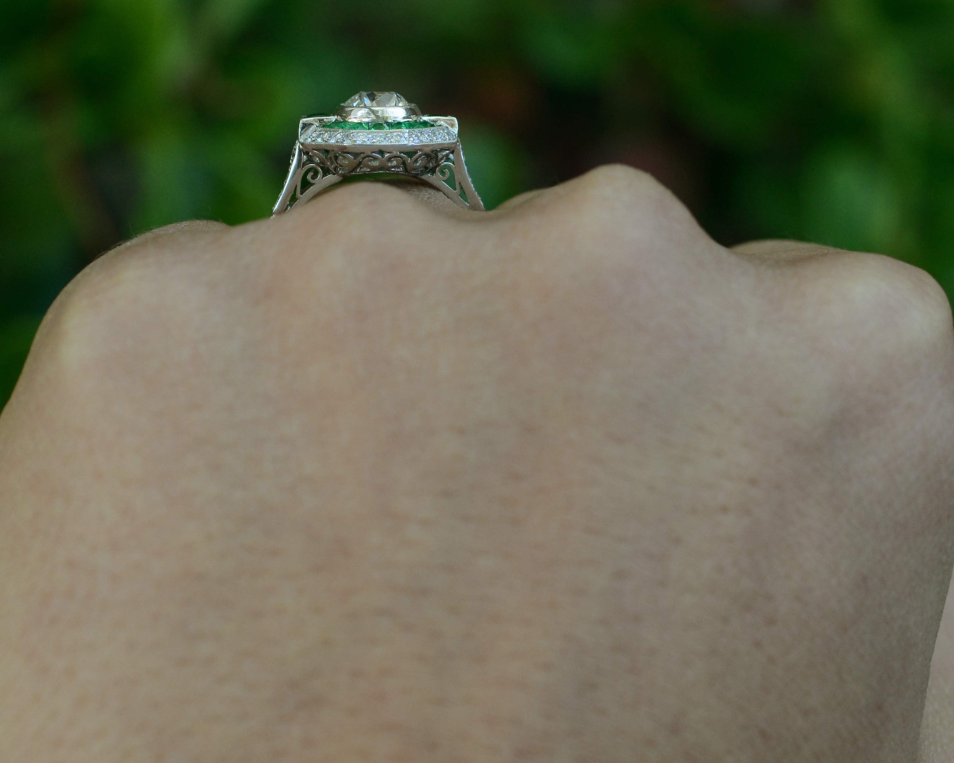 A hand crafted diamond emerald engagement ring, fabricated in the Art Deco style.