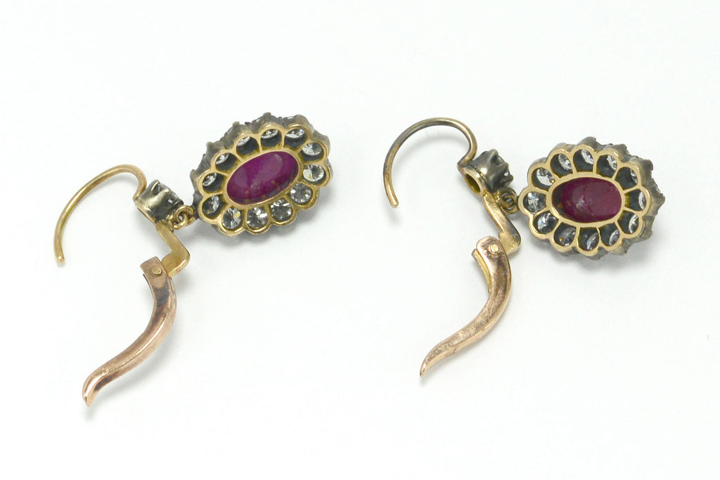 Silver topped 18k gold oval ruby diamond cluster earrings.