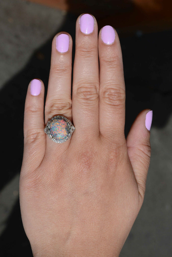 This cabochon dome opal statement ring is accented with a halo of diamonds.