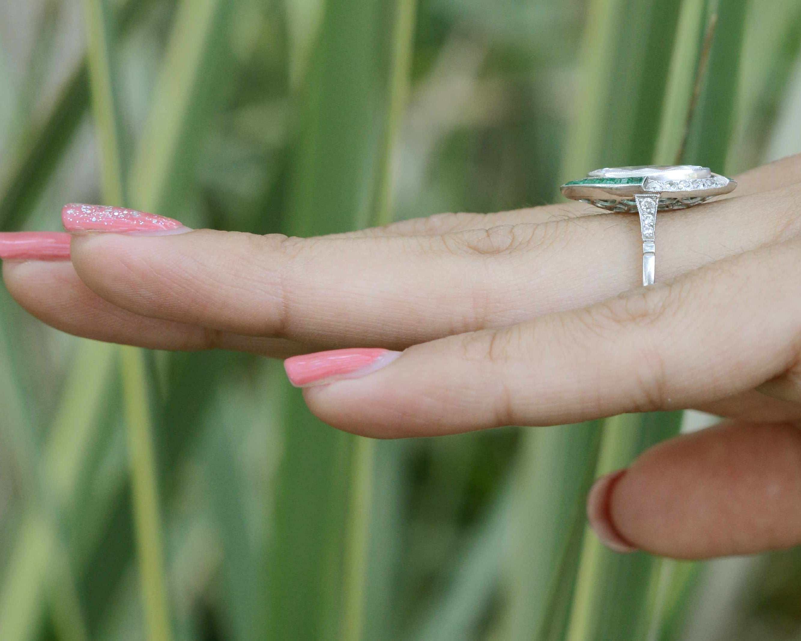 A unique diamond and emerald platinum engagement ring.