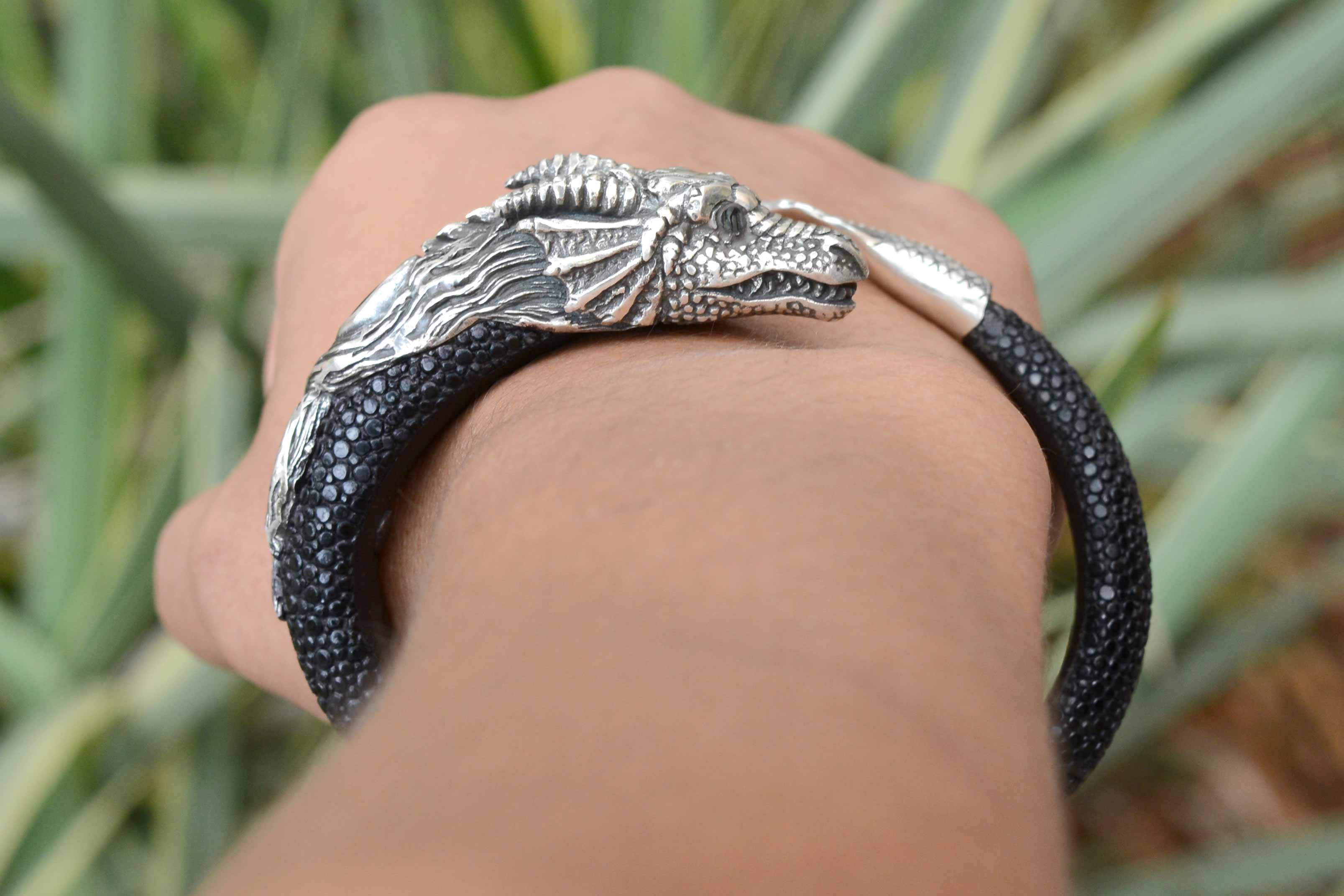 this leather cuff bangle has a silver dragon head and tail at the end of the wrap.