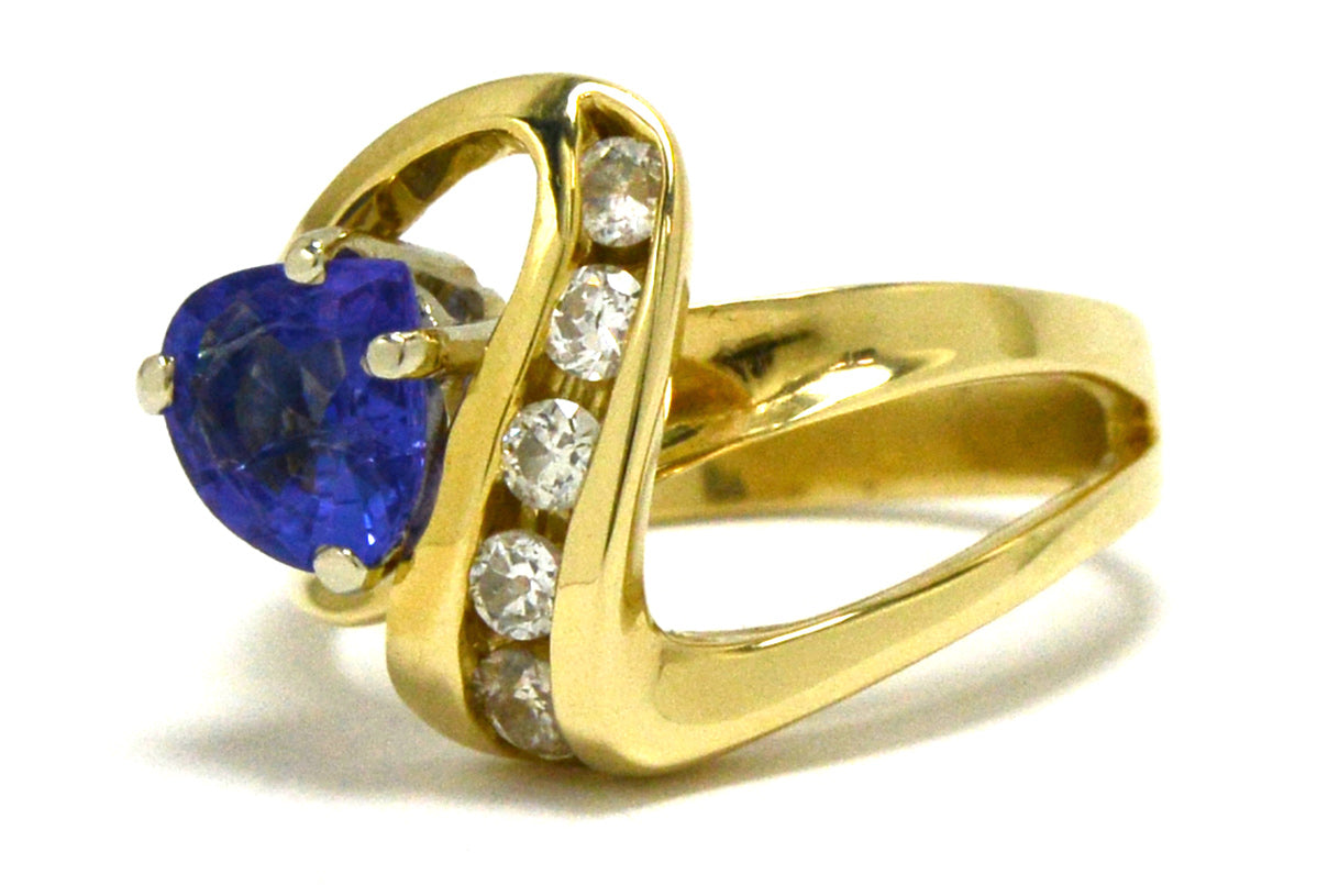 An asymmetrical 14k gold ring design with a trillion cut tanzanite.