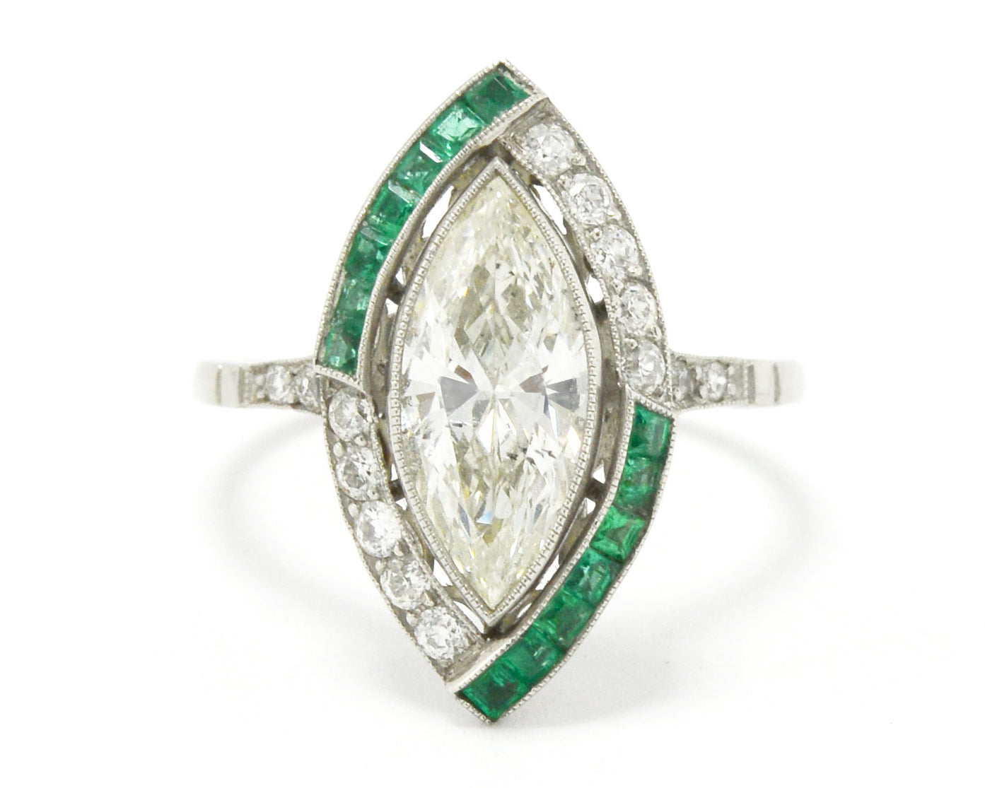 French cut emeralds accent the large marquise cut diamond in this platinum engagement ring.