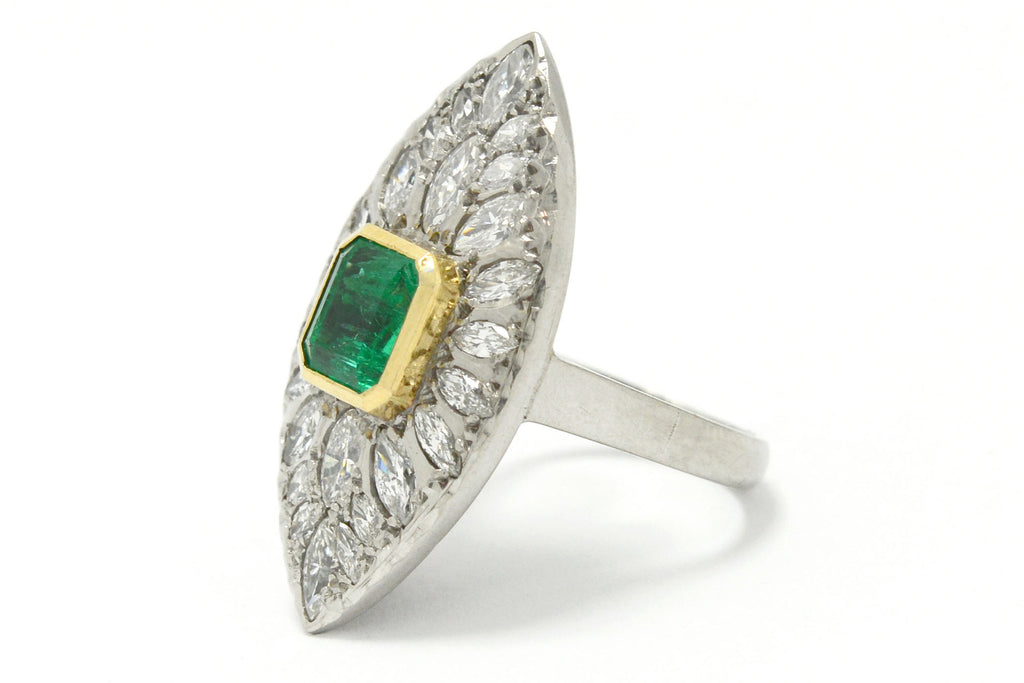 An 18k yellow gold bezel supports the two carat emerald in this stunning cluster statement ring.