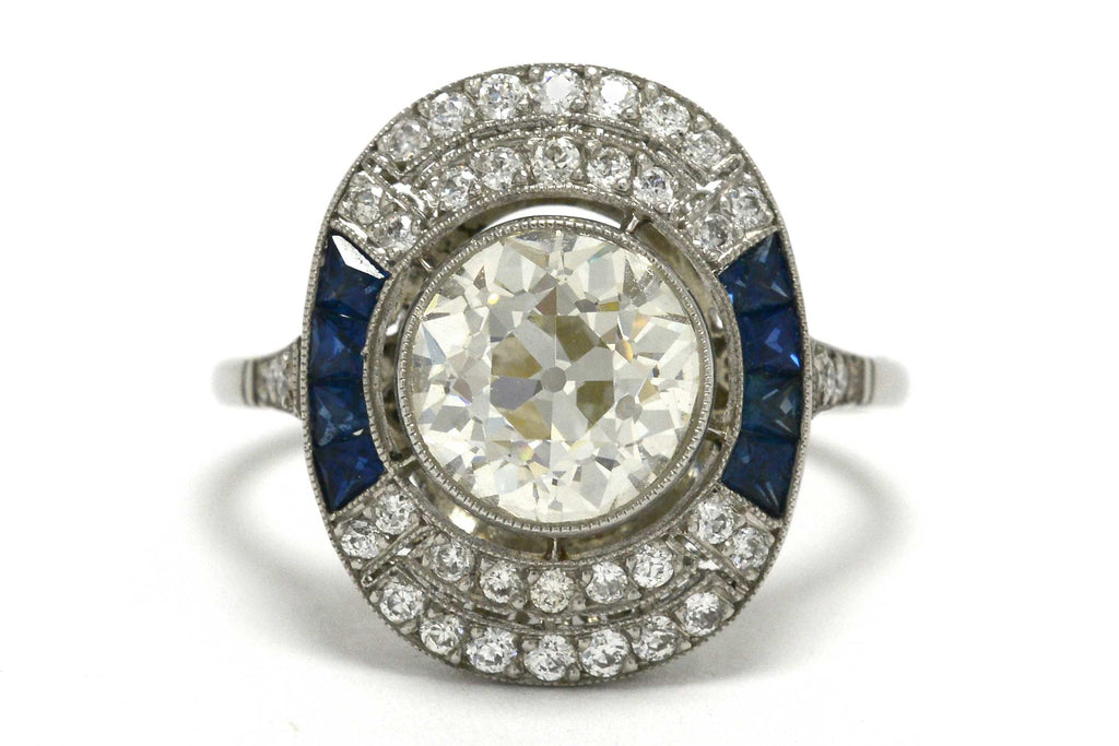 An old mine brilliant diamond cocktail ring with blue sapphire sides.