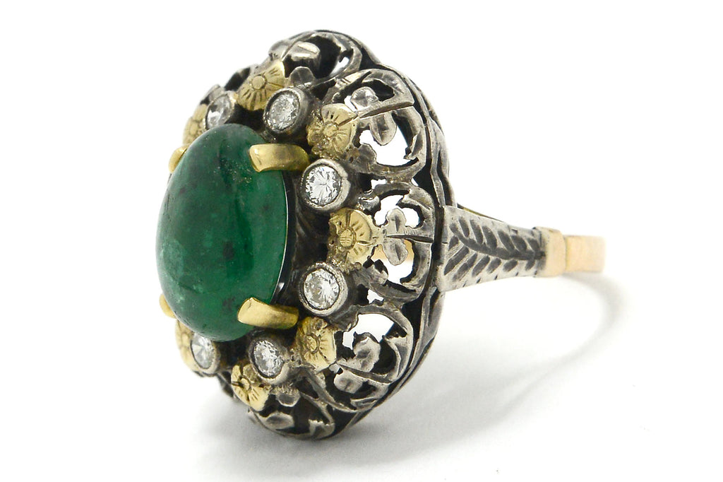 A floral, three carat emerald dome ring crafted of silver and gold.