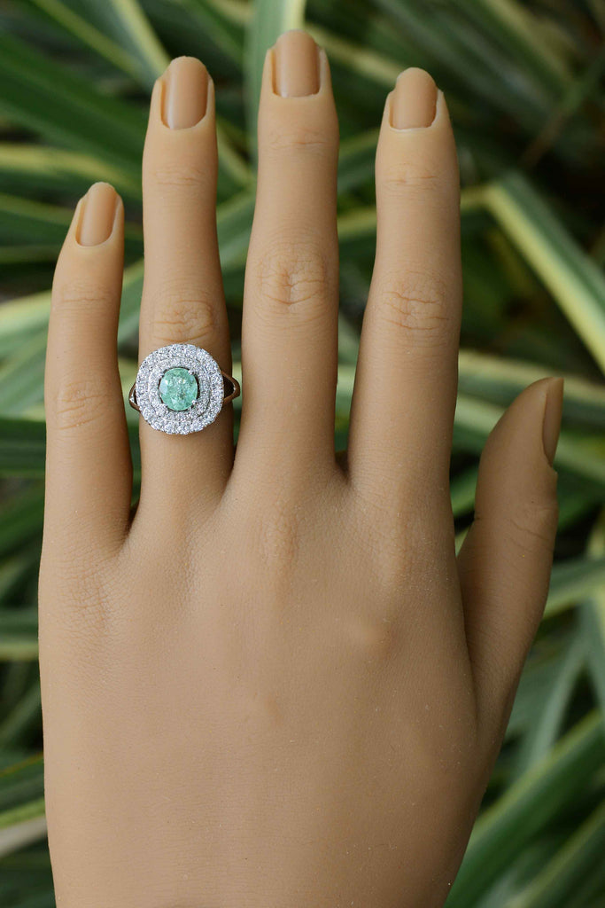 The central gem is certified by the Gemological Institute Laboratories as natural Paraiba and of a captivating, bluish, sea-foam green.