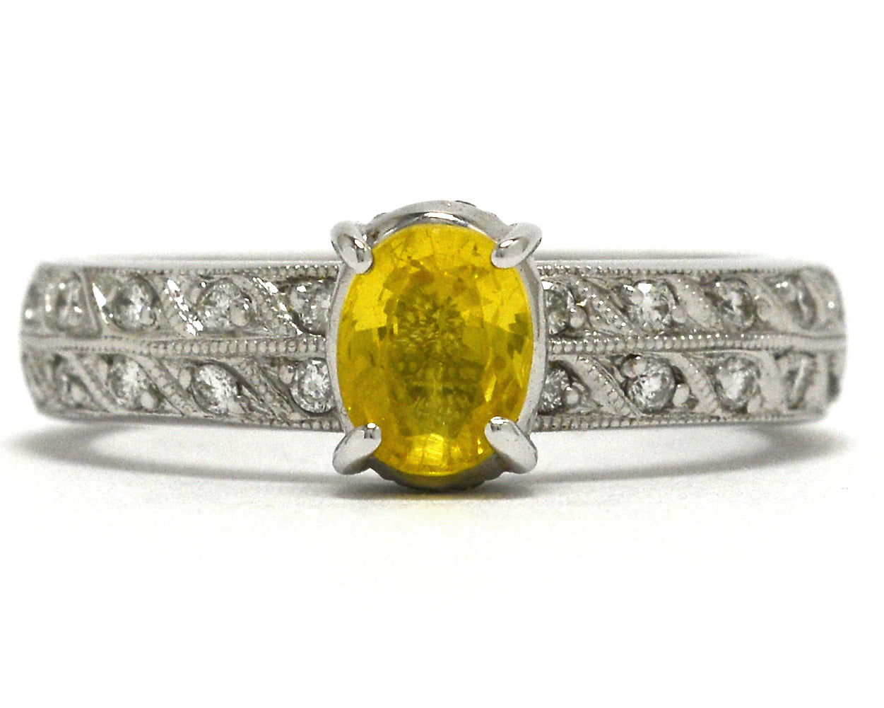 1 carat oval faceted yellow sapphire wedding ring with 2 rows of diamonds on the band.