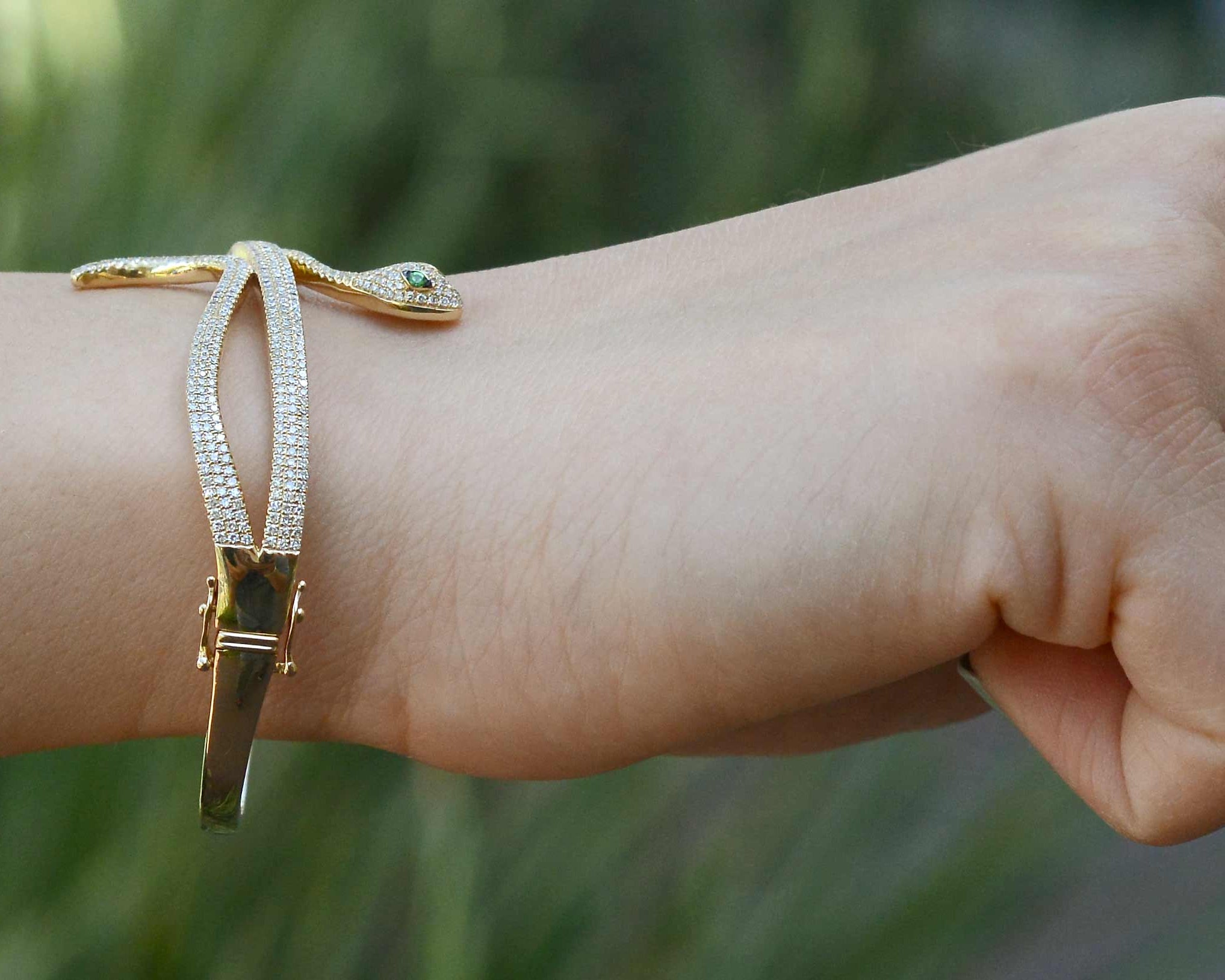 A modern gold snake bracelet with 2 safety clasps.